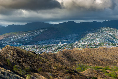 Aerial view of townscape and mountains against sky