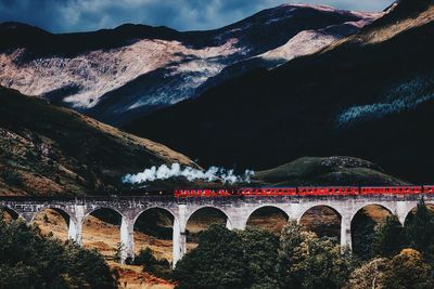 Arch bridge against cloudy sky