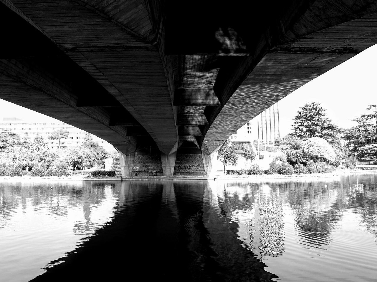 connection, bridge - man made structure, water, built structure, architecture, river, bridge, engineering, reflection, waterfront, tree, low angle view, transportation, long, arch bridge, tranquility, sky, footbridge, nature, support