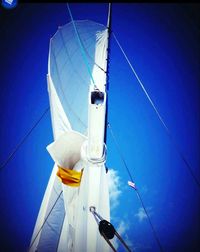 Low angle view of power lines against blue sky