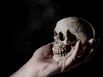 Close-up of human hand against black background