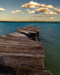 Pier over sea against sky during sunset