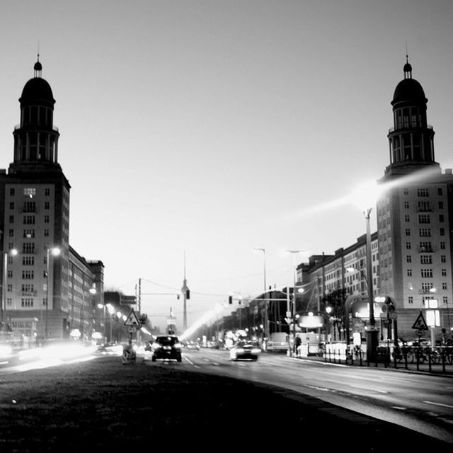 building exterior, architecture, built structure, car, transportation, street, city, road, clear sky, land vehicle, street light, mode of transport, city street, city life, incidental people, sky, copy space, tower, travel, travel destinations