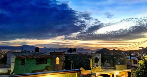 Houses in town against cloudy sky