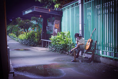 Woman sitting in yard against building