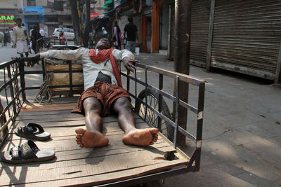 Rear view of man sleeping on bench