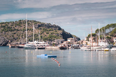 Sailboats moored on sea against sky