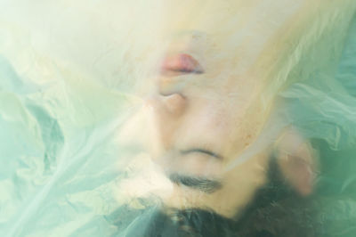Close-up portrait of young woman swimming in pool