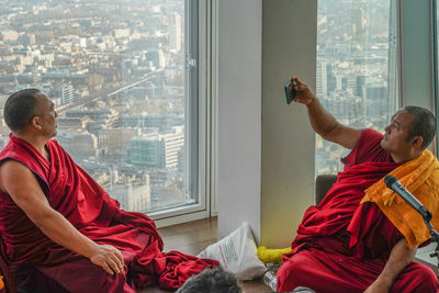 Men sitting by window in city