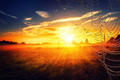Scenic view of silhouette field against sky during sunset