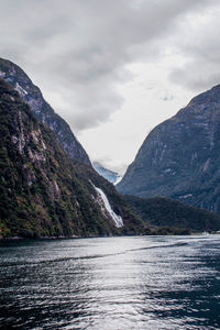 Scenic view of lake by mountains against sky