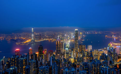 Illuminated cityscape against sky at night