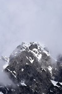 Low angle view of snow covered mountain against sky