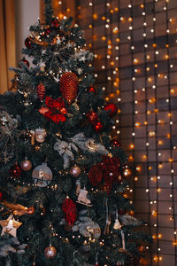 Red silver festive christmas balls and toys hanging on the christmas tree. new year's details