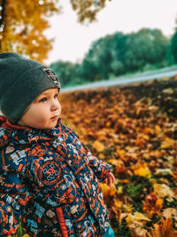 Girl looking away while standing on land during autumn
