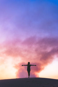 Rear view of silhouette man standing against sky