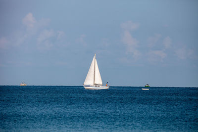 Sailboat sailing on sea against sky