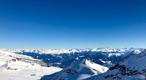 Scenic view of snowcapped mountains against clear blue sky