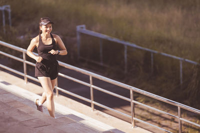 Woman looking away while standing on railing