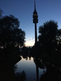 Silhouette of communications tower against sky at night