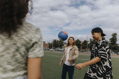 Smiling teenagers playing ball together