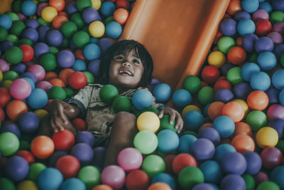 Full length portrait of smiling boy playing bath ball