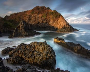 Scenic view of rocks in sea against sky