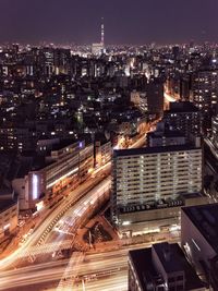 Aerial view of skyscrapers in city lit up at night