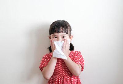 Portrait of boy standing against wall