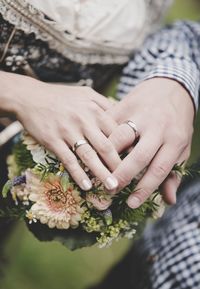 Midsection of woman hand holding flowering plant