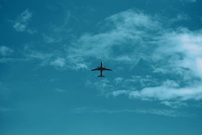 Low angle view of silhouette airplane against sky