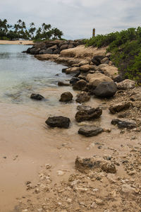 Rocks on beach against sky