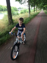 Boy riding bicycle on road