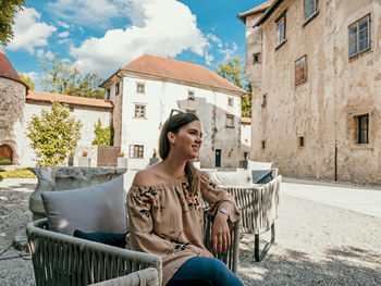 Portrait of happy young woman inside a castle courtyard.