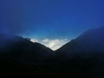 Scenic view of mountains against blue sky