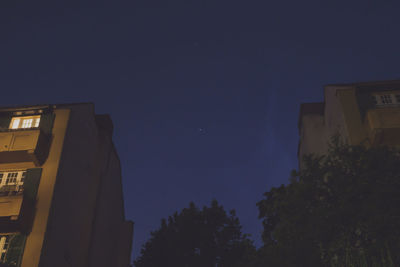 Low angle view of buildings against sky at night