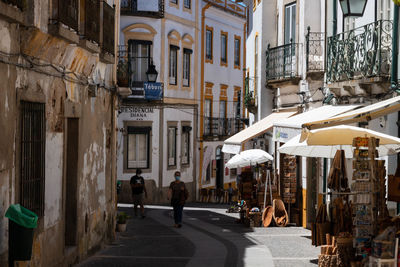 People walking on street amidst buildings in city