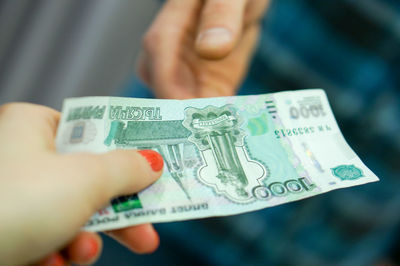 Close-up of hand holding paper currency indoors