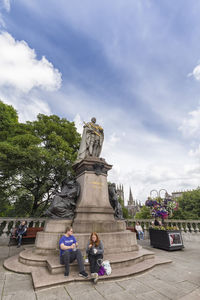 Statue of people against sky