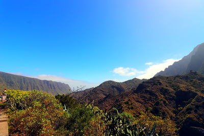 Scenic view of mountains against blue sky