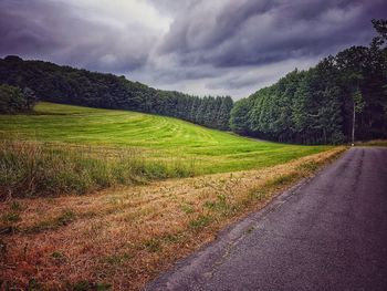 Road amidst green landscape against sky