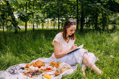 Portrait of young woman sitting on field