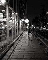 Man moving on illuminated walkway at night