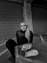 Portrait of woman sitting against wall