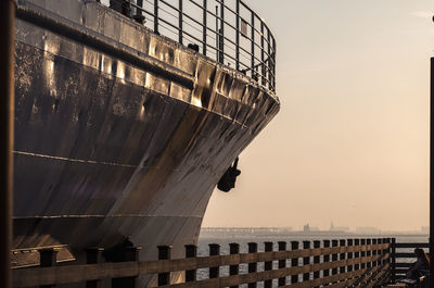 Ship moored in sea at sunset