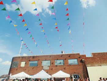 People by building below bunting flags decoration during traditional festival