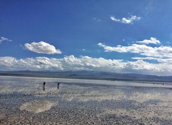 Scenic view of beach against cloudy sky