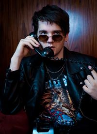 Portrait of young man holding sunglasses