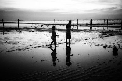 People at beach against sky