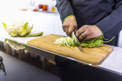 Midsection of person preparing food on cutting board